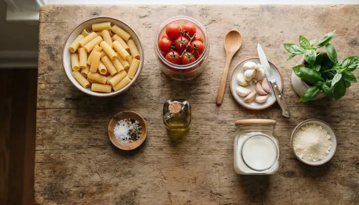 Ingredients for creamy red sauce pasta laid out on a kitchen counter